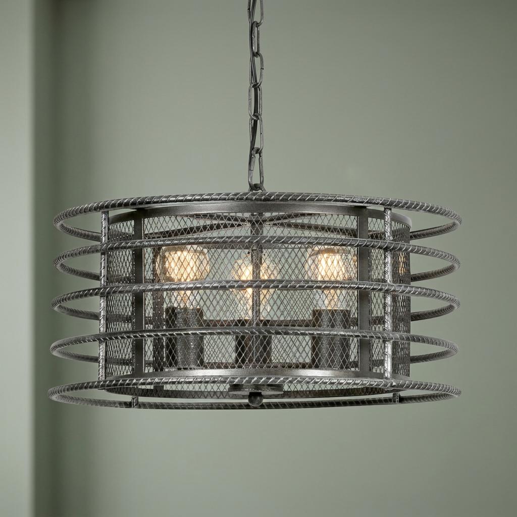 Industrial 3-light pendant with a silver brushed black mesh and coil drum shade hanging against a green wall.