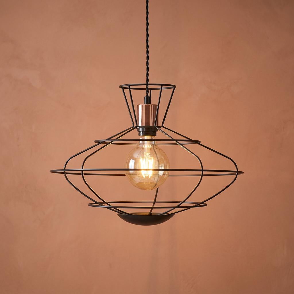 Geometric black wire caged ceiling pendant with copper detail and glowing bulb on a terracotta background.
