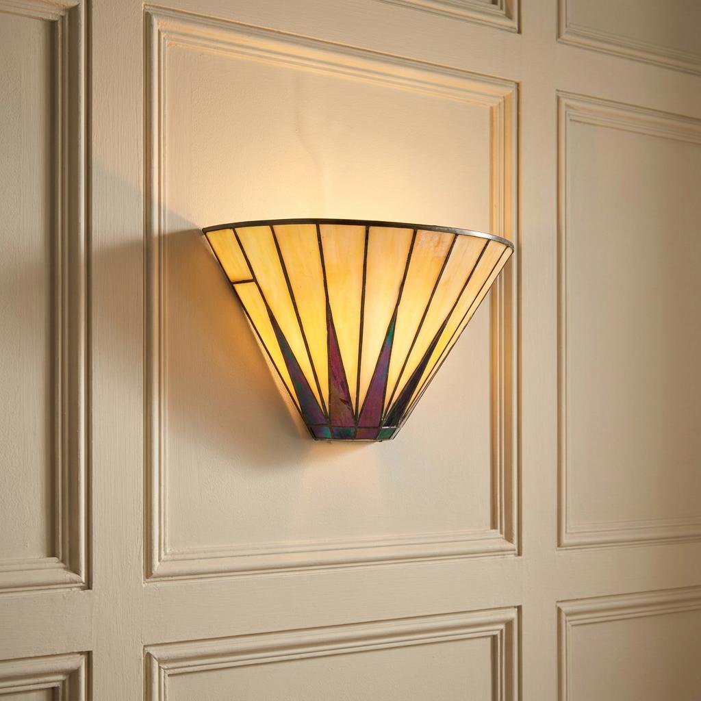 Tiffany-style fan wall light with iridescent glass details glowing on a cream-paneled wall.