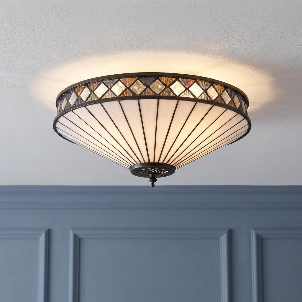 Large flush Tiffany ceiling light with Art Deco white glass panels and geometric borders on a white ceiling.
