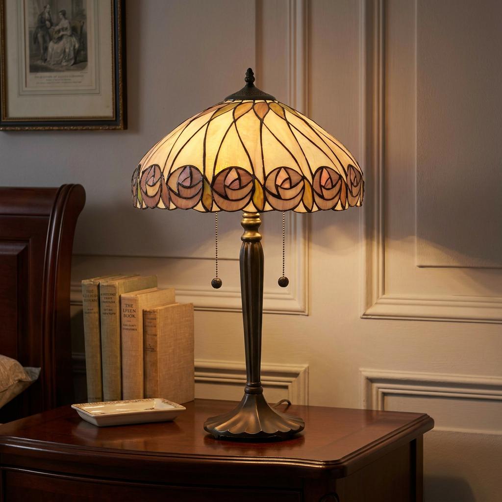 Tiffany table lamp with a floral rose patterned shade on a dark wood table against a paneled wall.