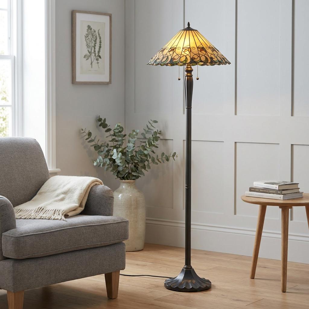 Ornate Tiffany floor lamp with a stained-glass shade standing in a cozy living room corner beside an armchair.