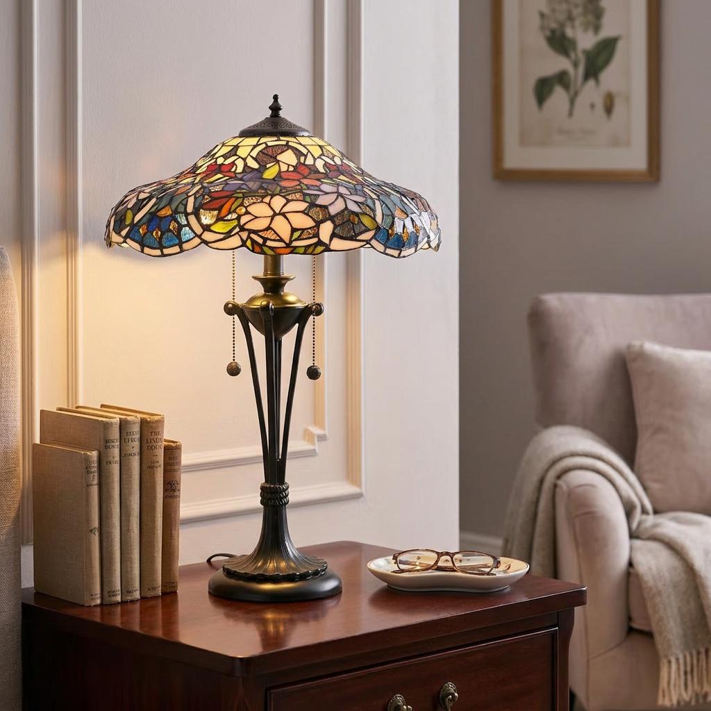 Tiffany table lamp with a colorful floral stained glass shade on a dark wood nightstand in a cozy room.