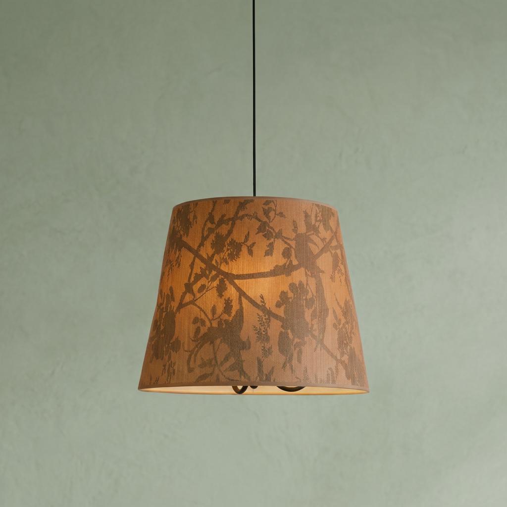 Tapered pendant light with a silhouetted bird and branch pattern on a painted sand recycled paper shade.