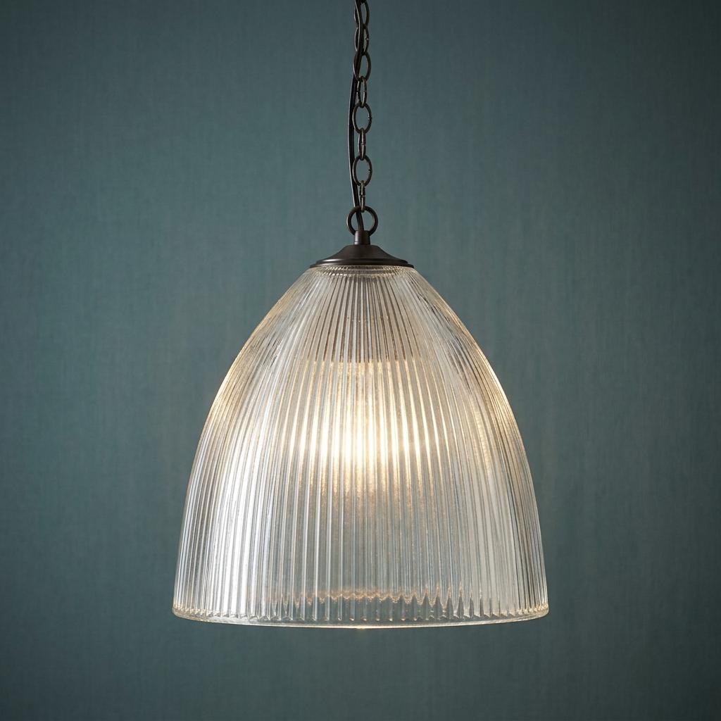 Elongated prismatic glass pendant light with a ribbed clear shade hanging against a dark teal wall.