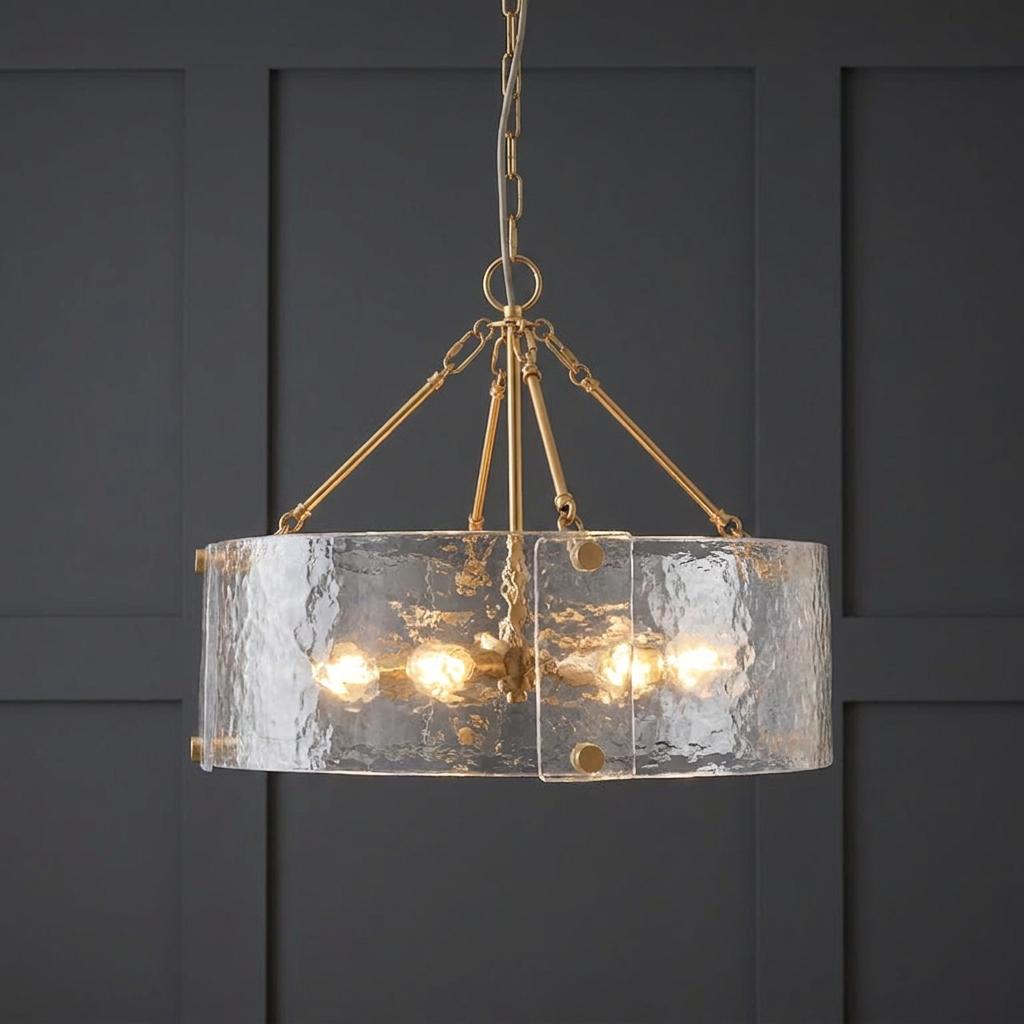 Brass pendant chandelier with curved textured glass panels hanging against a dark paneled wall.