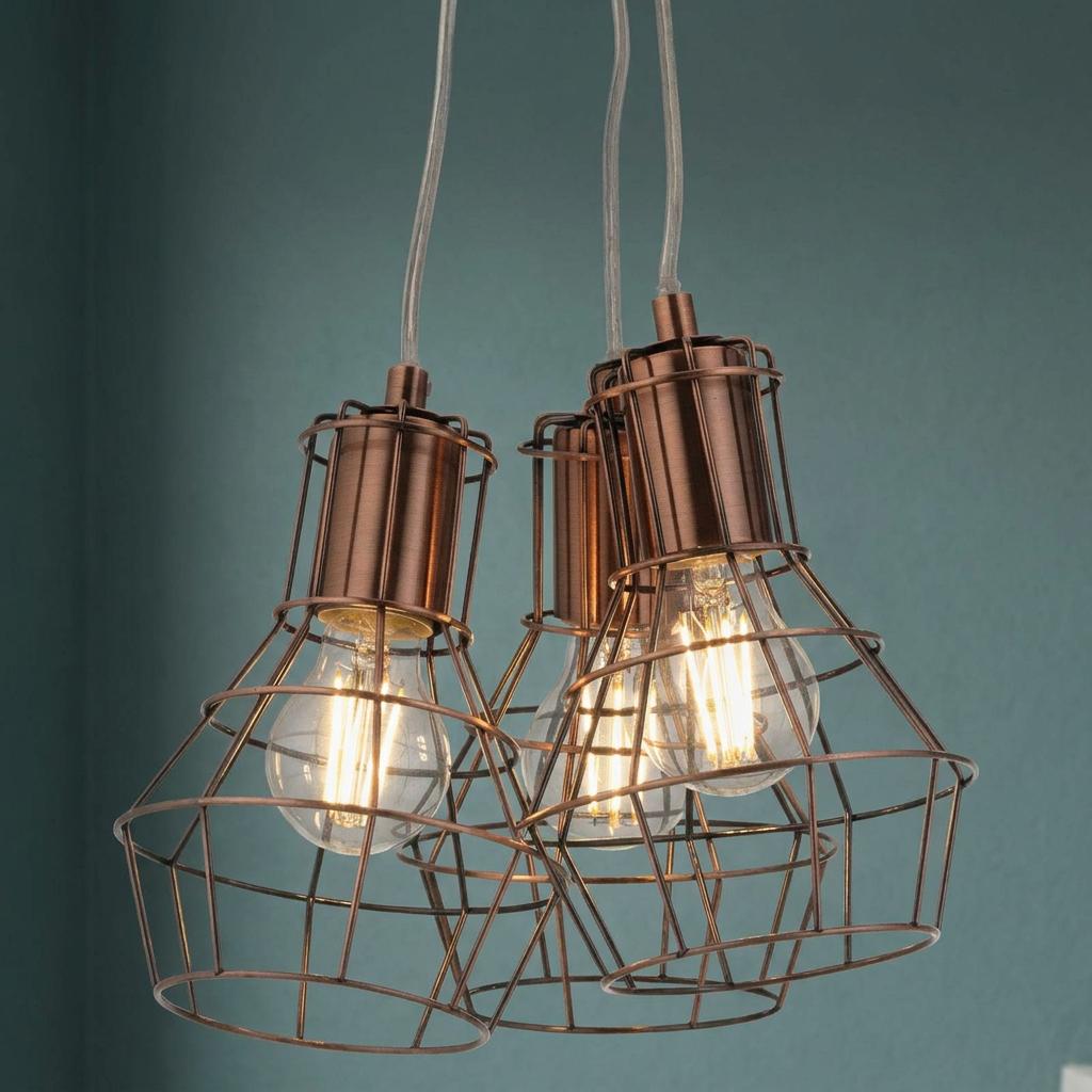 Copper caged 3-light cluster pendant with glowing filament bulbs against a teal blue wall.