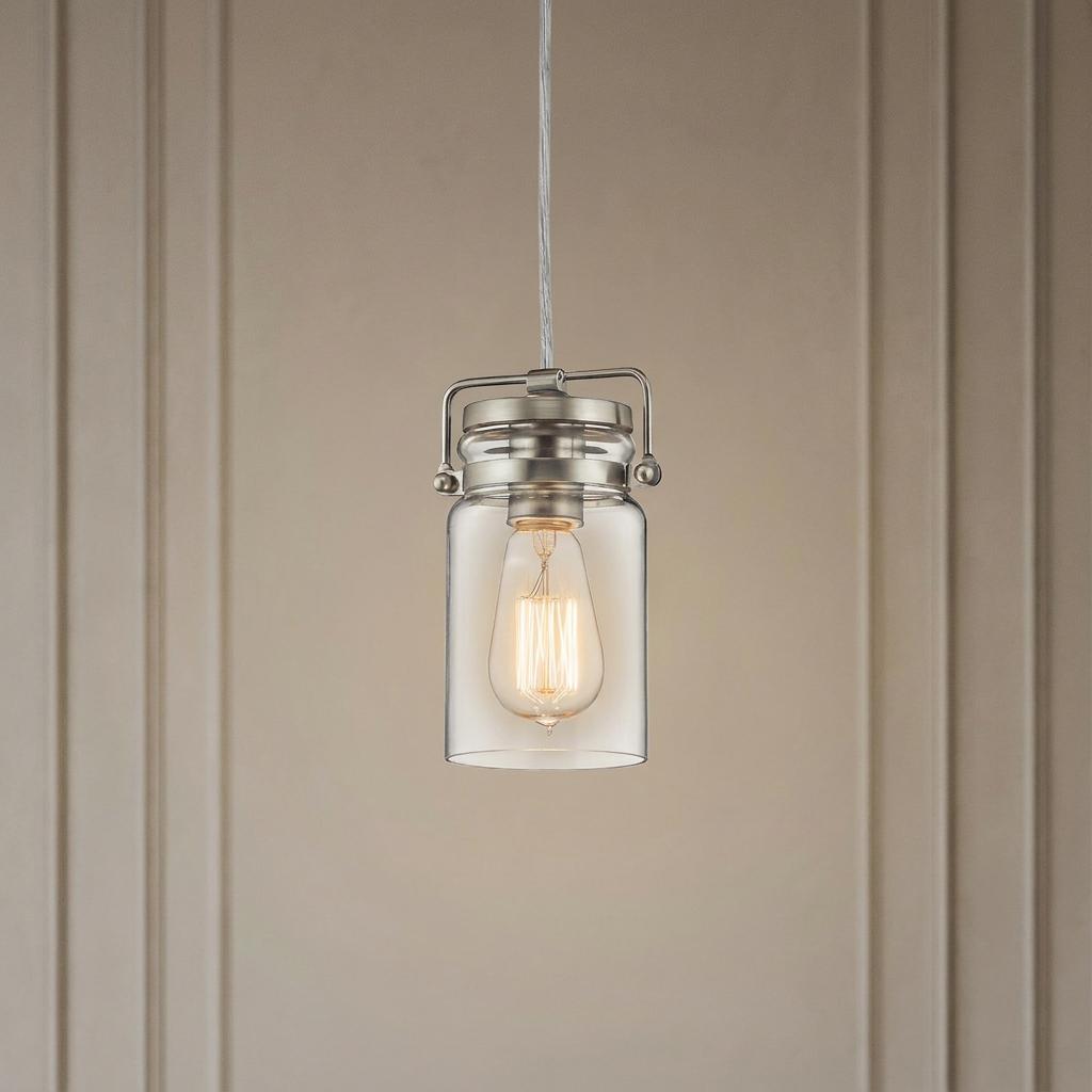 Industrial mini pendant light with a clear glass jar shade and an Edison bulb against a paneled wall.