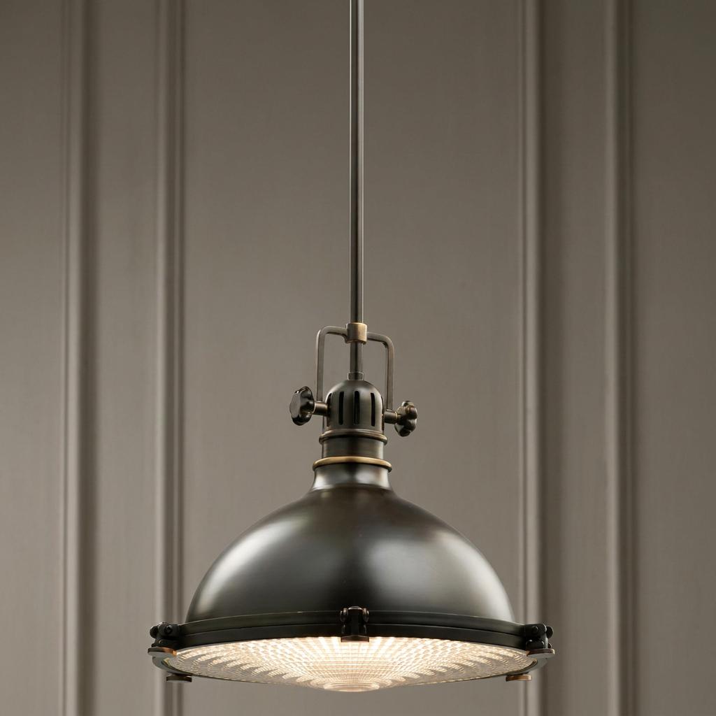 Kichler Hatteras Bay 33cm bronze pendant light with a domed shade and fresnel lens hanging in a room.