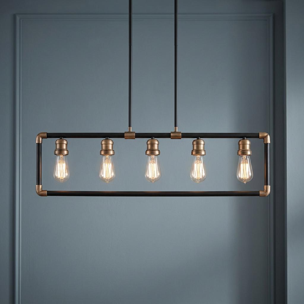 Industrial five-light linear chandelier with a black and brass frame and Edison bulbs against a blue wall.