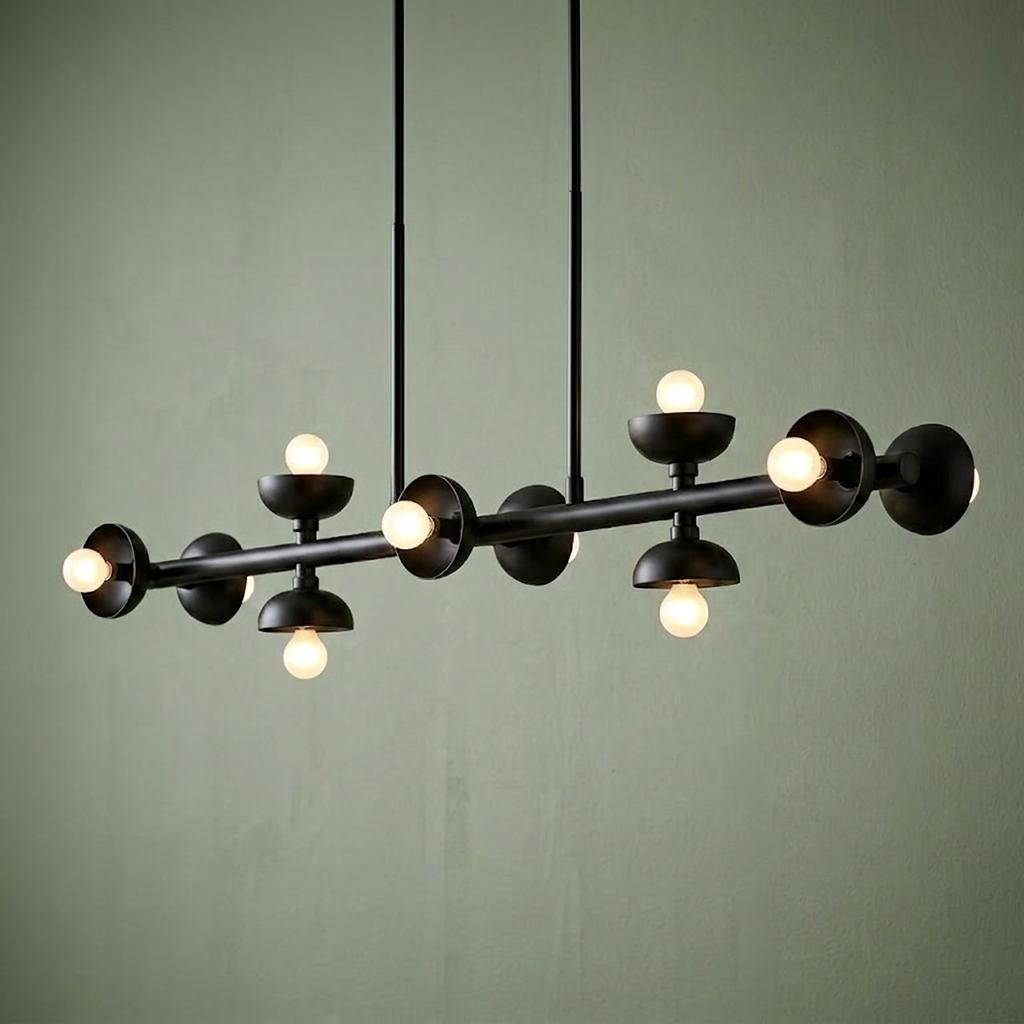 Modern black linear pendant light with ten globe bulbs and bowl accents against a textured green wall.
