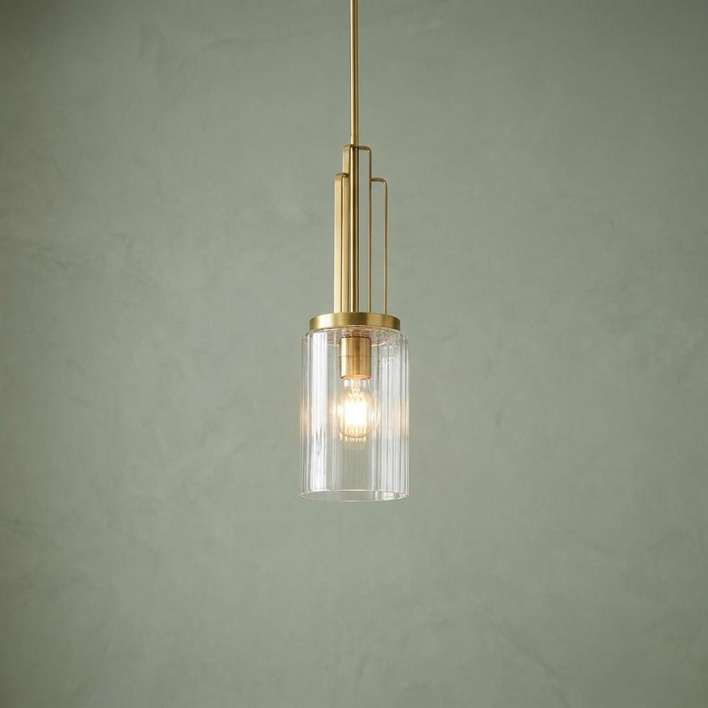 Kimrose mini brass pendant light with a fluted glass shade and Art Deco details against a sage green wall.