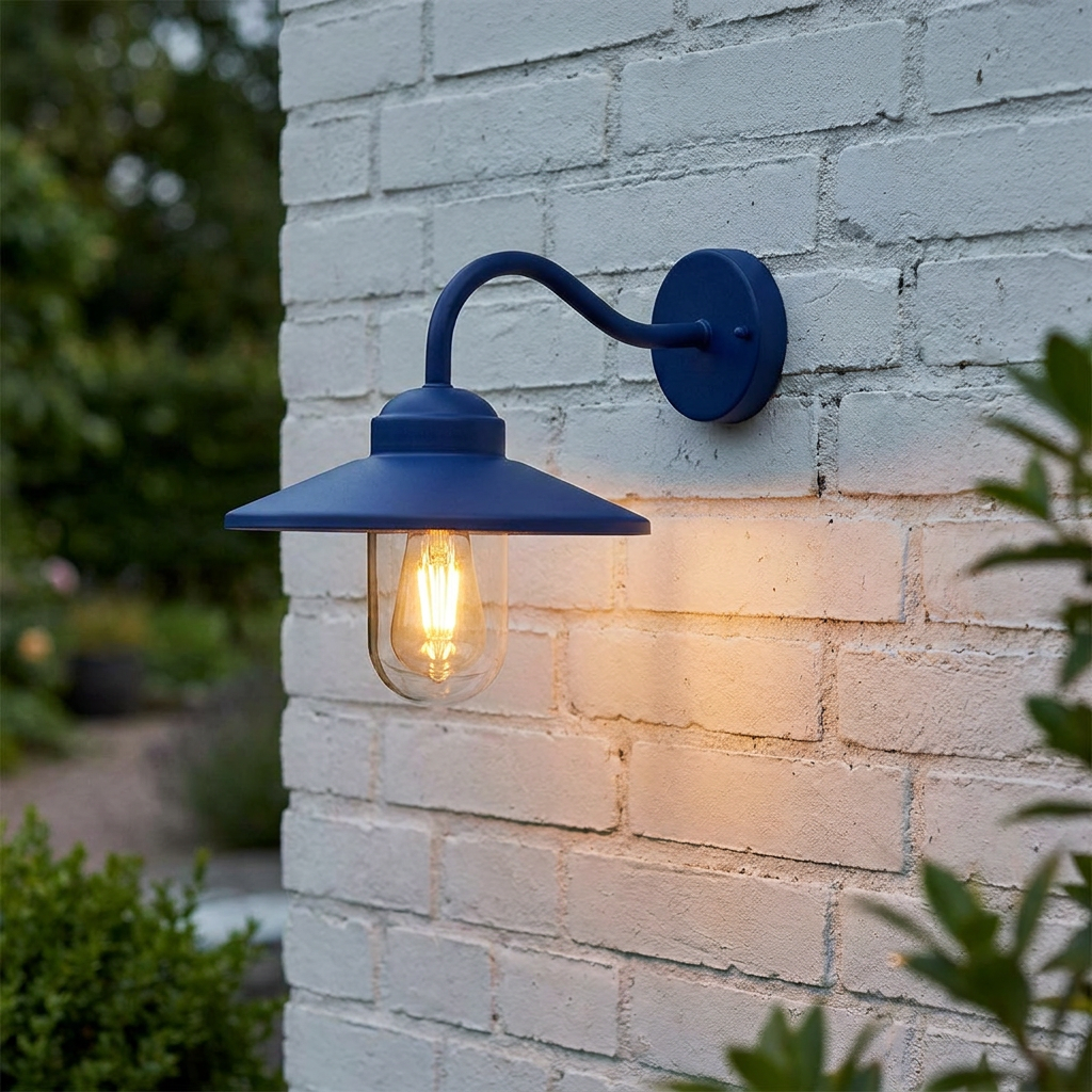 Blue industrial-style outdoor wall lantern with a warm glowing bulb mounted on a white brick wall.