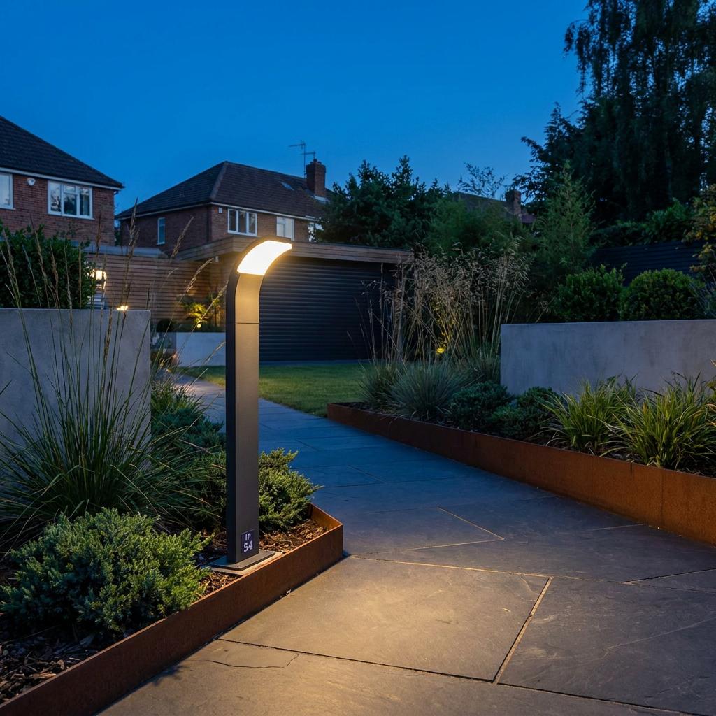 Sleek grey LED bollard post lighting a modern stone garden path at twilight.