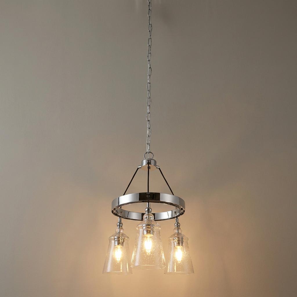 A Loras three-light chrome chandelier with bell-shaped seeded glass shades hanging from a silver chain.