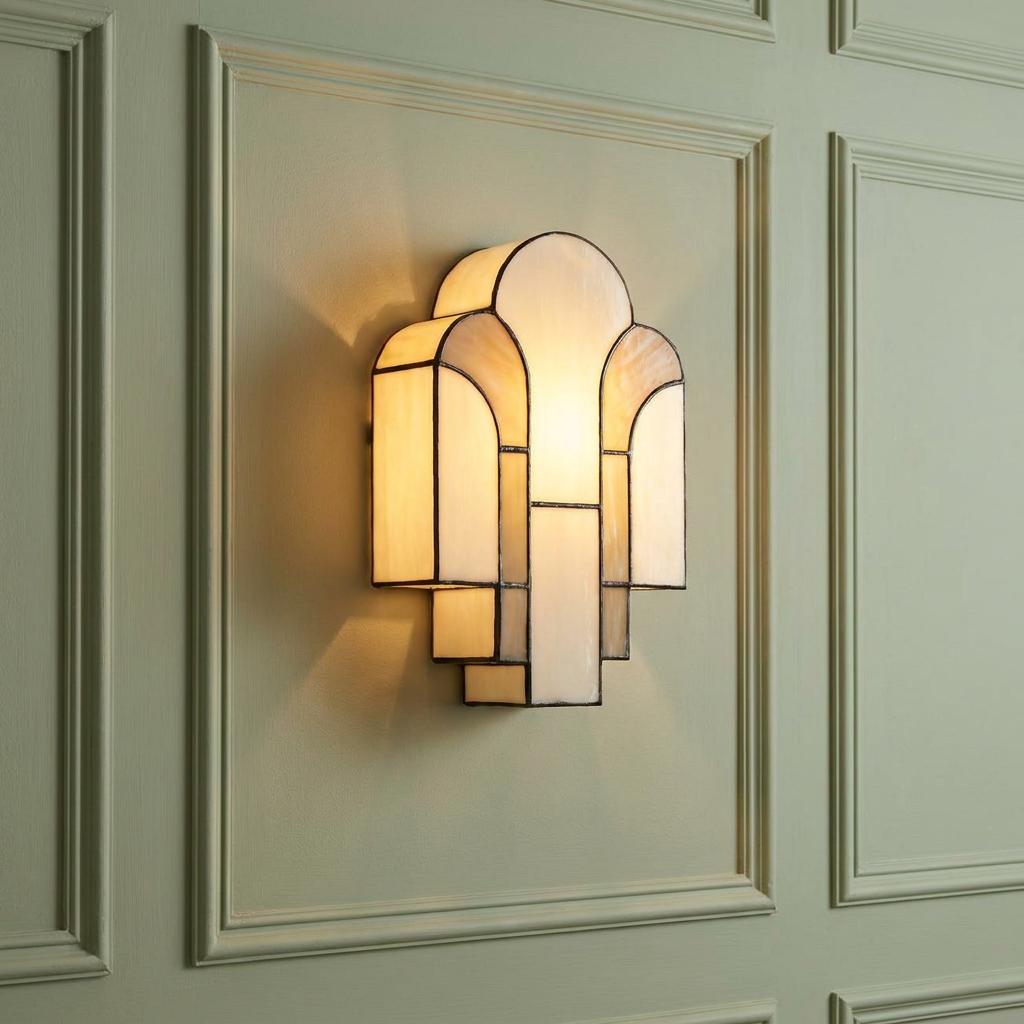 Art Deco Tiffany wall light with stepped cream glass panels on a sage green paneled wall.