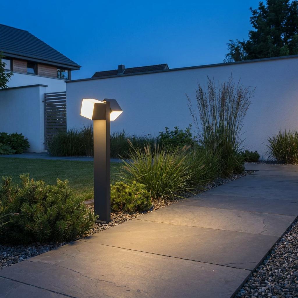 Modern grey bollard light with dual adjustable heads illuminating a slate garden path at dusk.