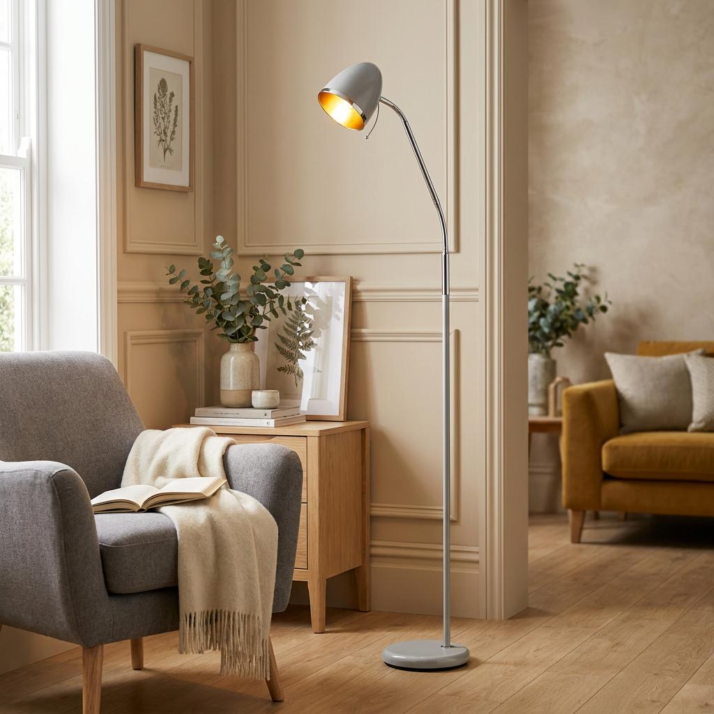 A Madison dark grey floor lamp with a gold interior illuminating a cozy living room corner.