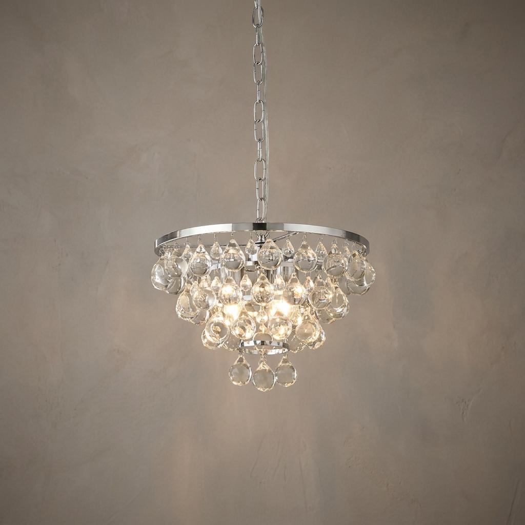 Lit 4-light chrome pendant featuring tiers of glass crystal droplets against a neutral textured wall.