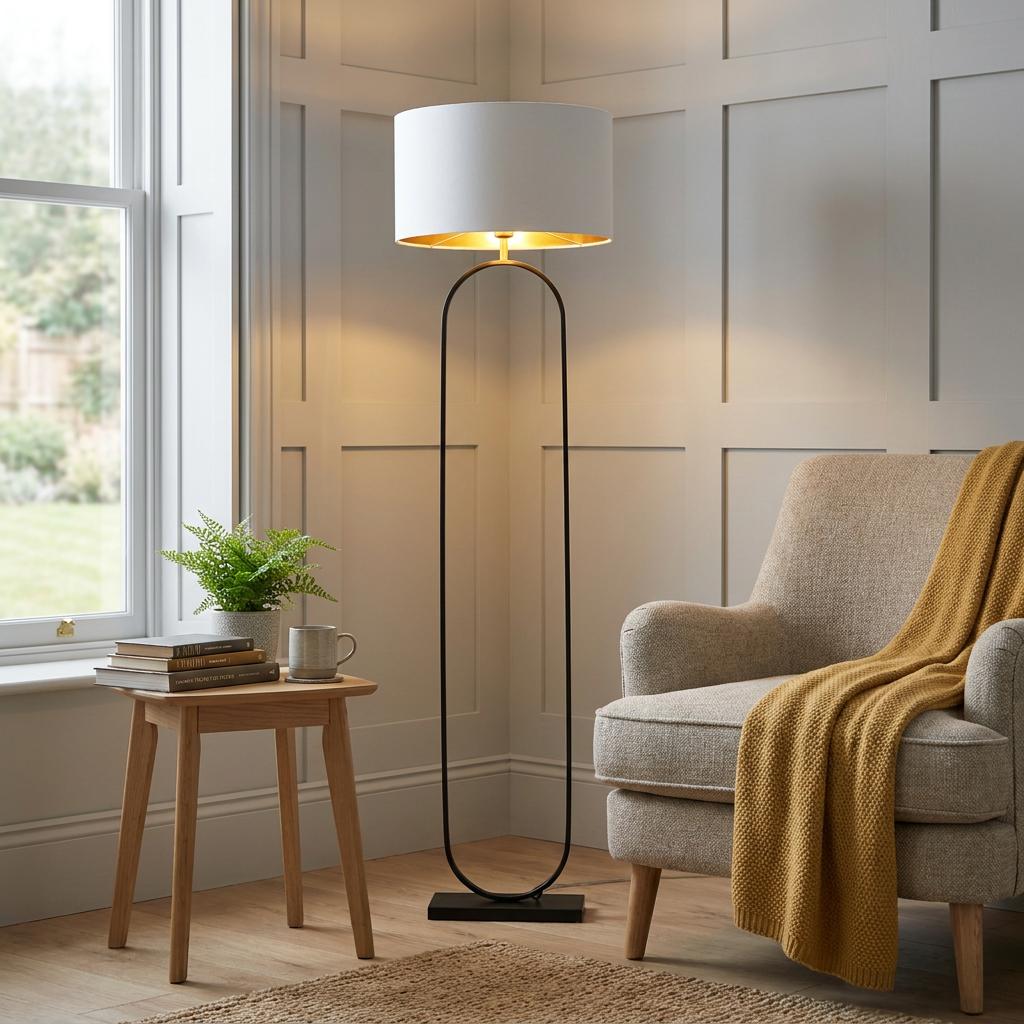 Matt black oval floor lamp with a grey velvet shade and gold interior in a modern living room corner.