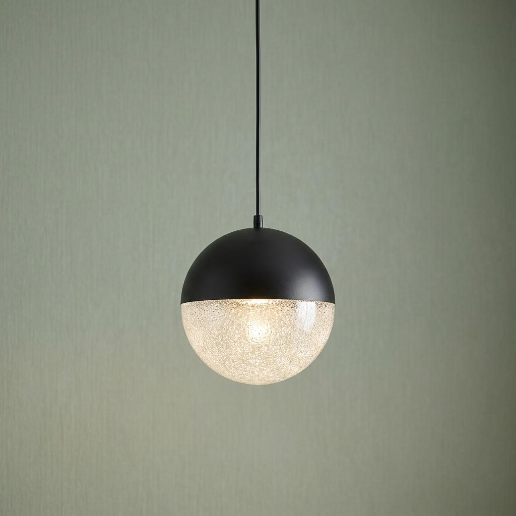 Moonlit LED black pendant light with a textured glass globe hanging against a green textured wall.