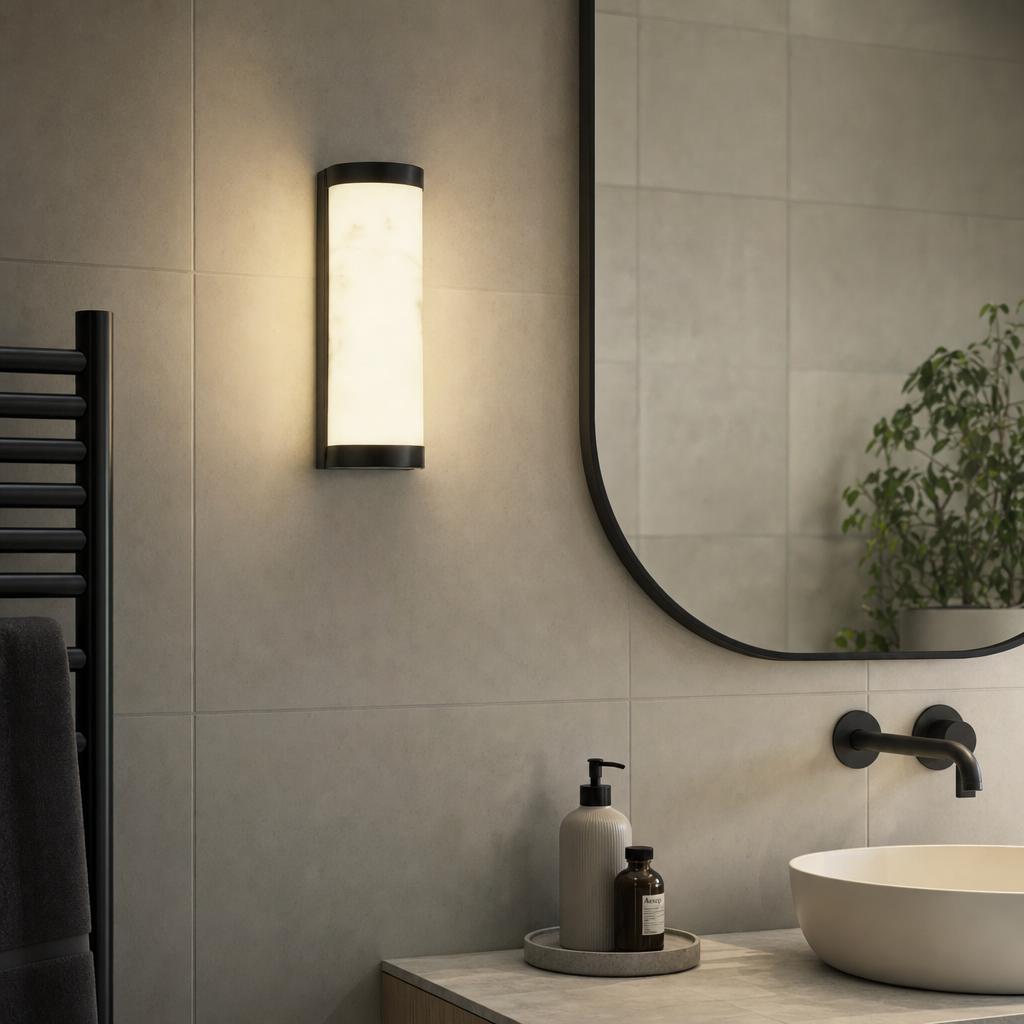 Cylindrical Nile LED wall light with marbleised resin and black trim mounted on a tiled bathroom wall.