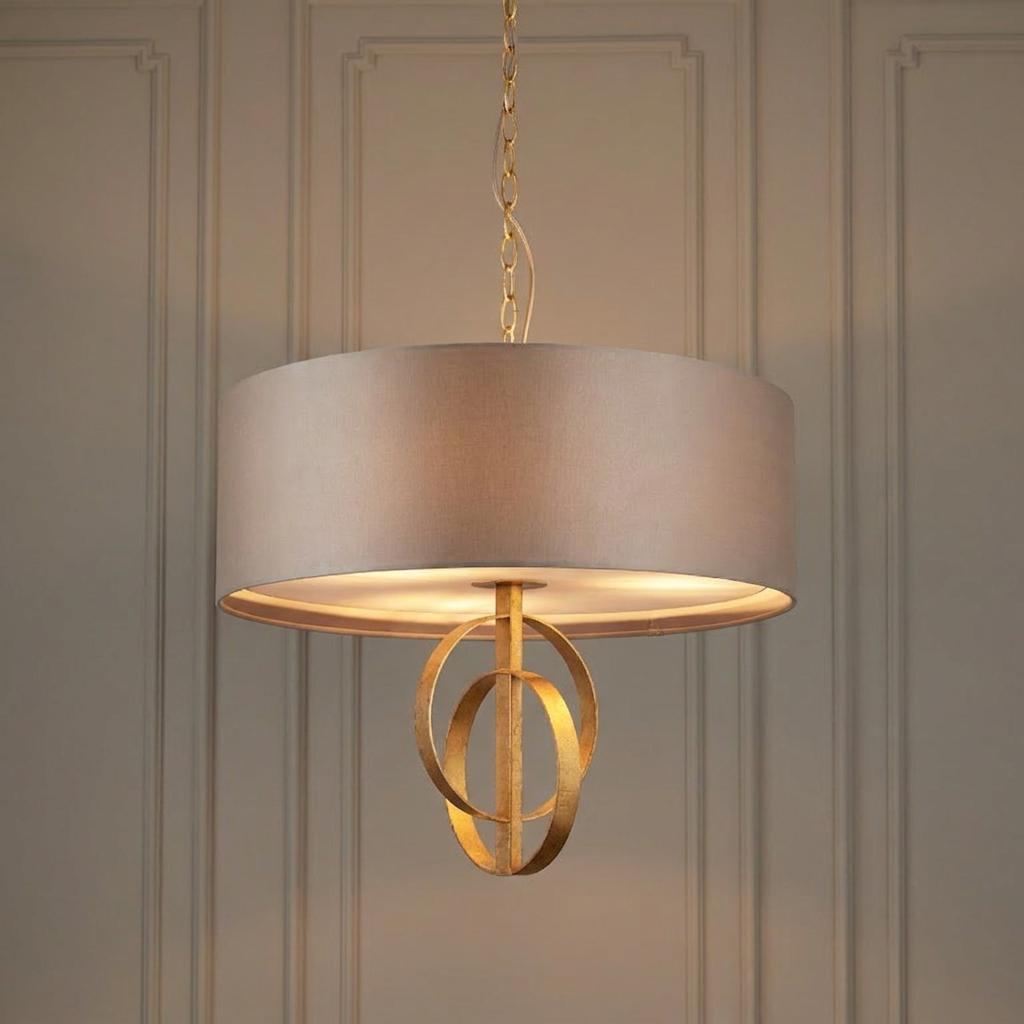 Norfolk 3-light pendant featuring a mink drum shade and gold leaf circular motif against a paneled wall.