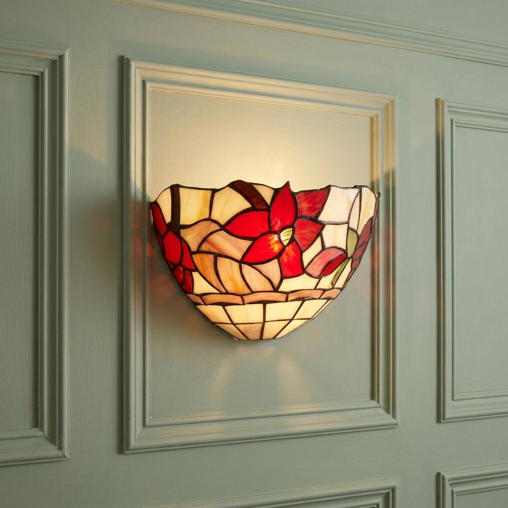 Tiffany wall light with red floral stained glass mounted on a light green paneled wall.