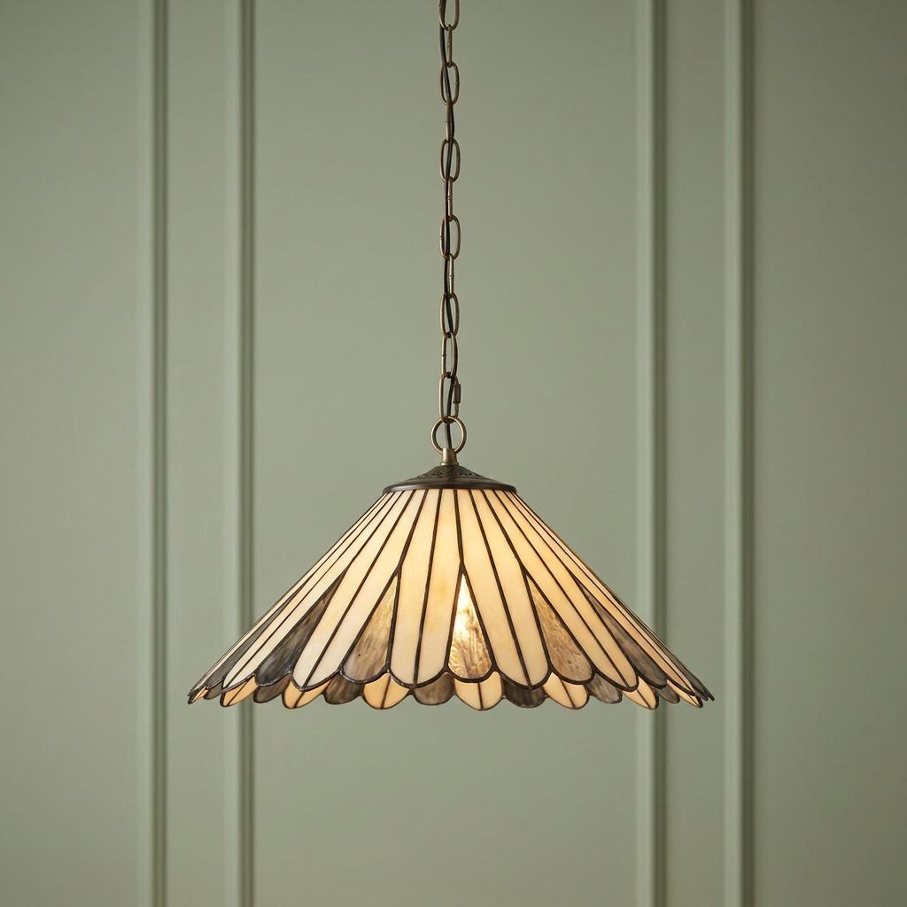 A Tiffany-style pendant light with a cream scalloped shade hangs against a light green paneled wall.