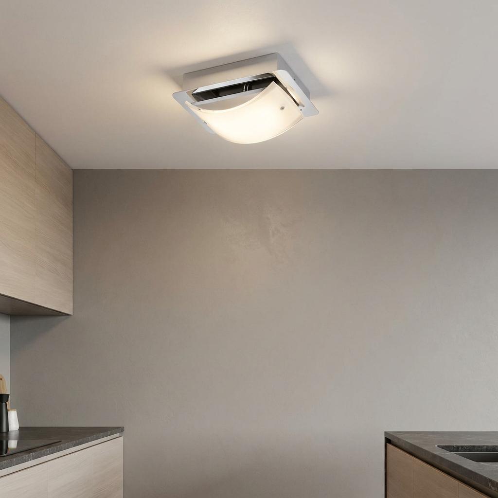 Modern chrome LED ceiling light with a curved frosted glass shade illuminating a contemporary kitchen.