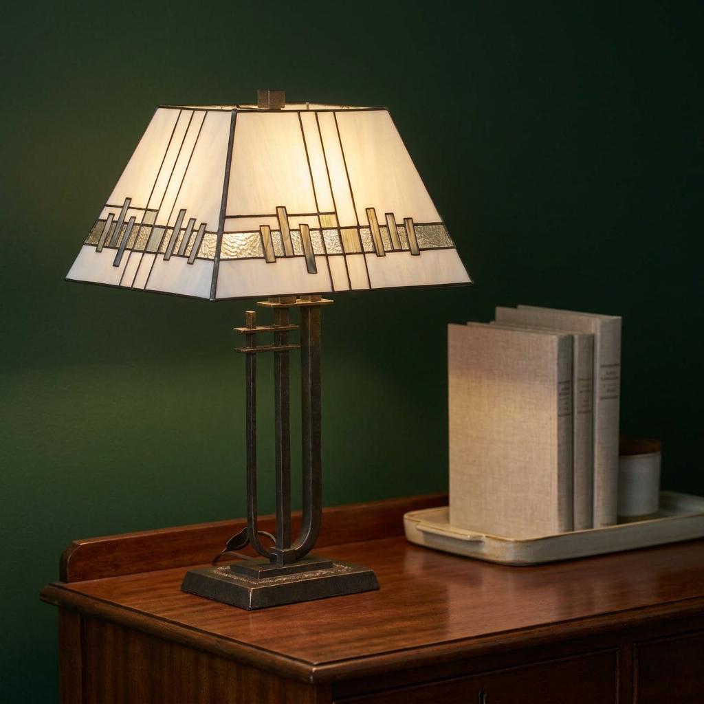 Lit Tiffany-style table lamp with geometric rectangular shade on a wooden sideboard against a dark green wall.