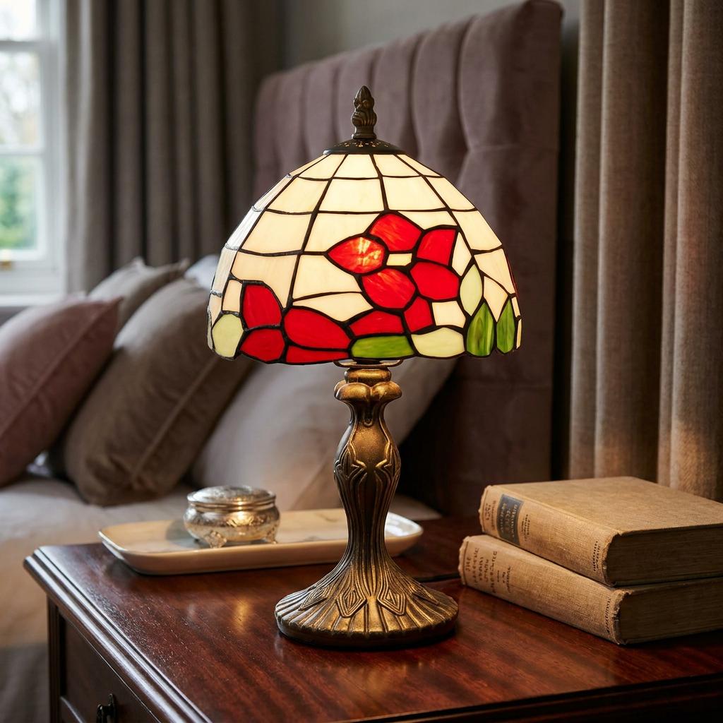 Tiffany-style bedside lamp with a red floral stained glass shade on a dark wood nightstand in a bedroom.