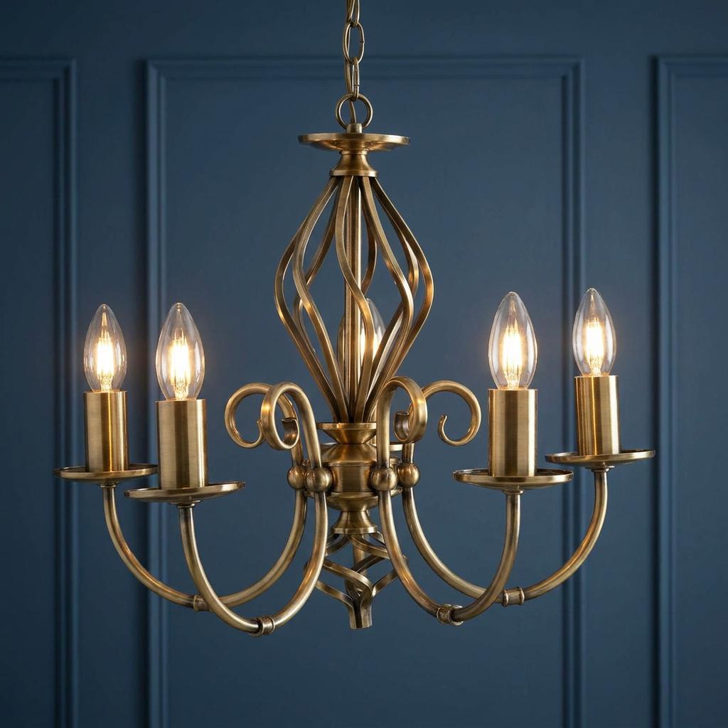 Antique brass 5-light chandelier with lit candle bulbs against a dark blue paneled wall.