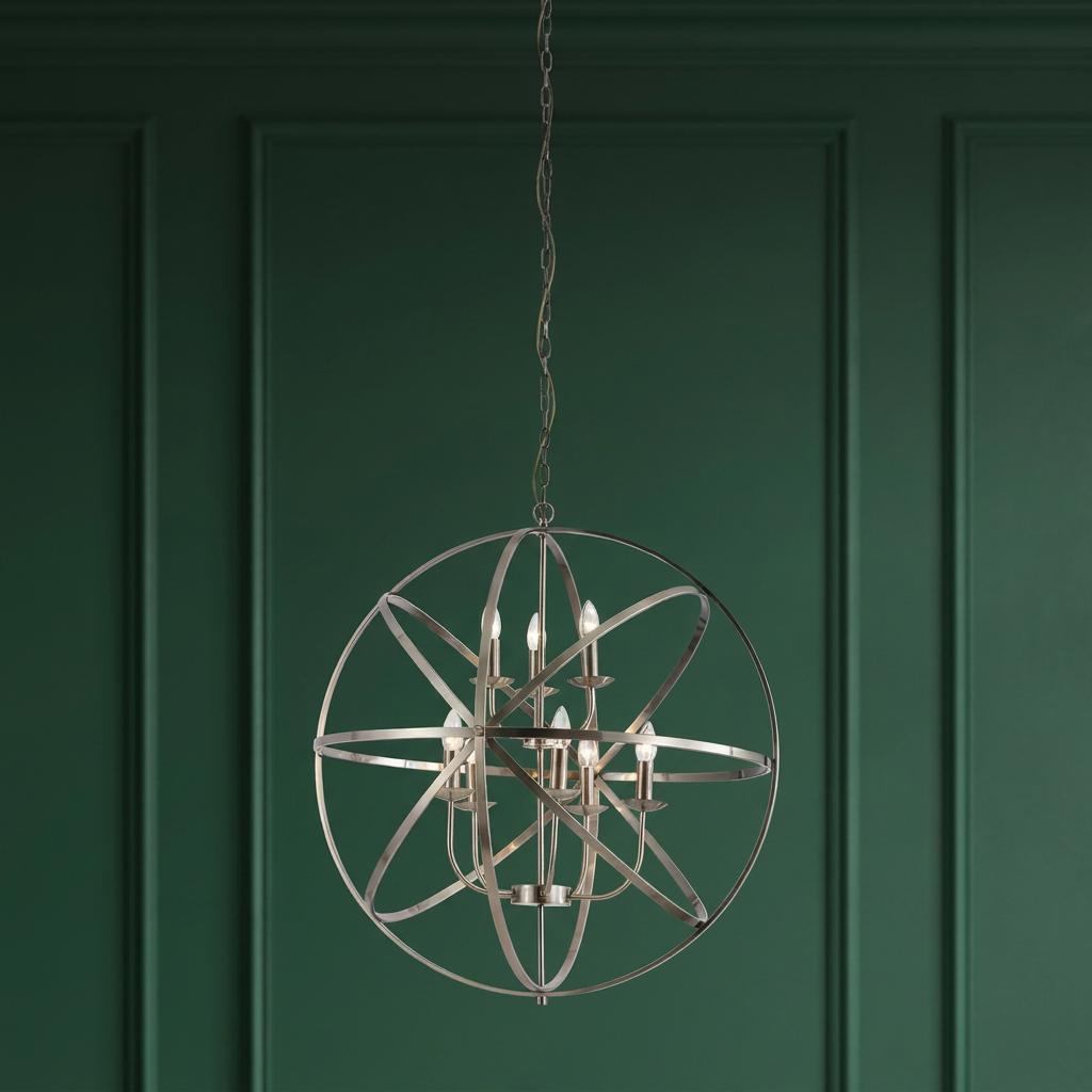 An orbital cage chandelier with candle-style bulbs hanging against a dark green paneled wall.