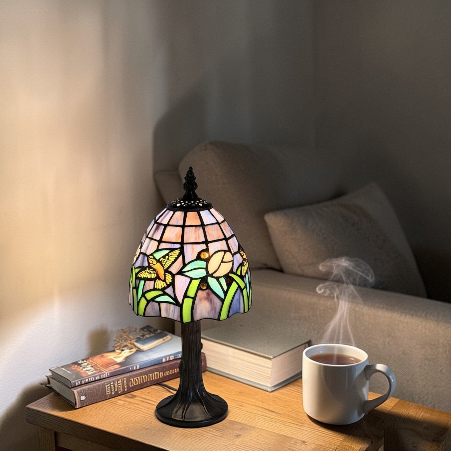 Stained glass lamp on a table with a cup of coffee and books in a cosy setting.