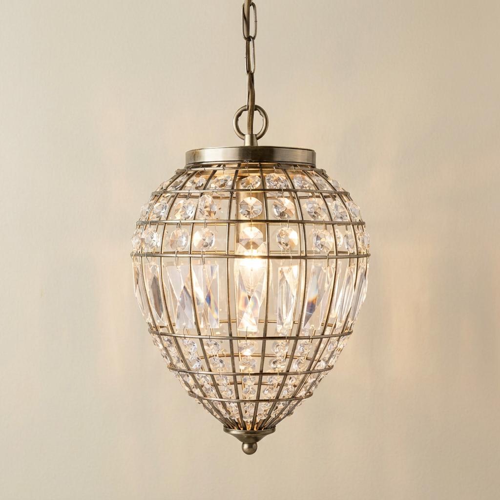 Ornate pineapple-shaped pendant light with antique brass cage and crystal beads against a neutral wall.