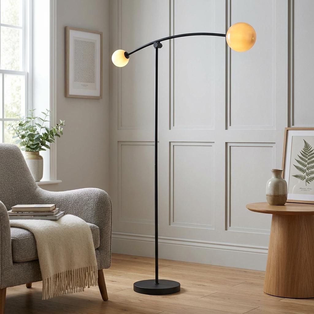Modern black floor lamp with two glowing amber globe shades, situated in a living room with panelled walls.