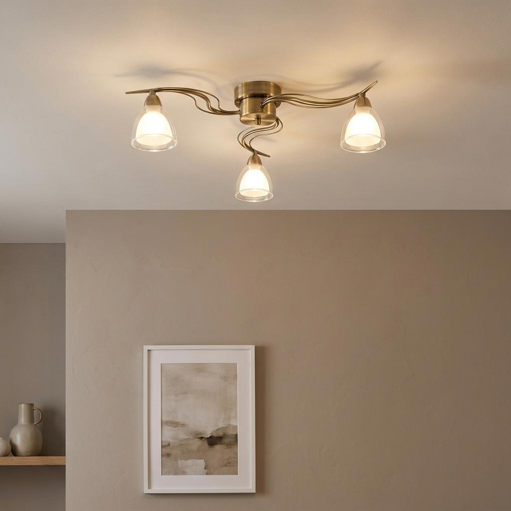Portland 3-light antique brass flush ceiling fixture with wavy arms and frosted glass shades on a white ceiling.