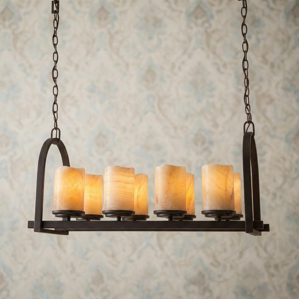 8-light island chandelier with glowing onyx candle shades and a palladian bronze frame against patterned wallpaper.