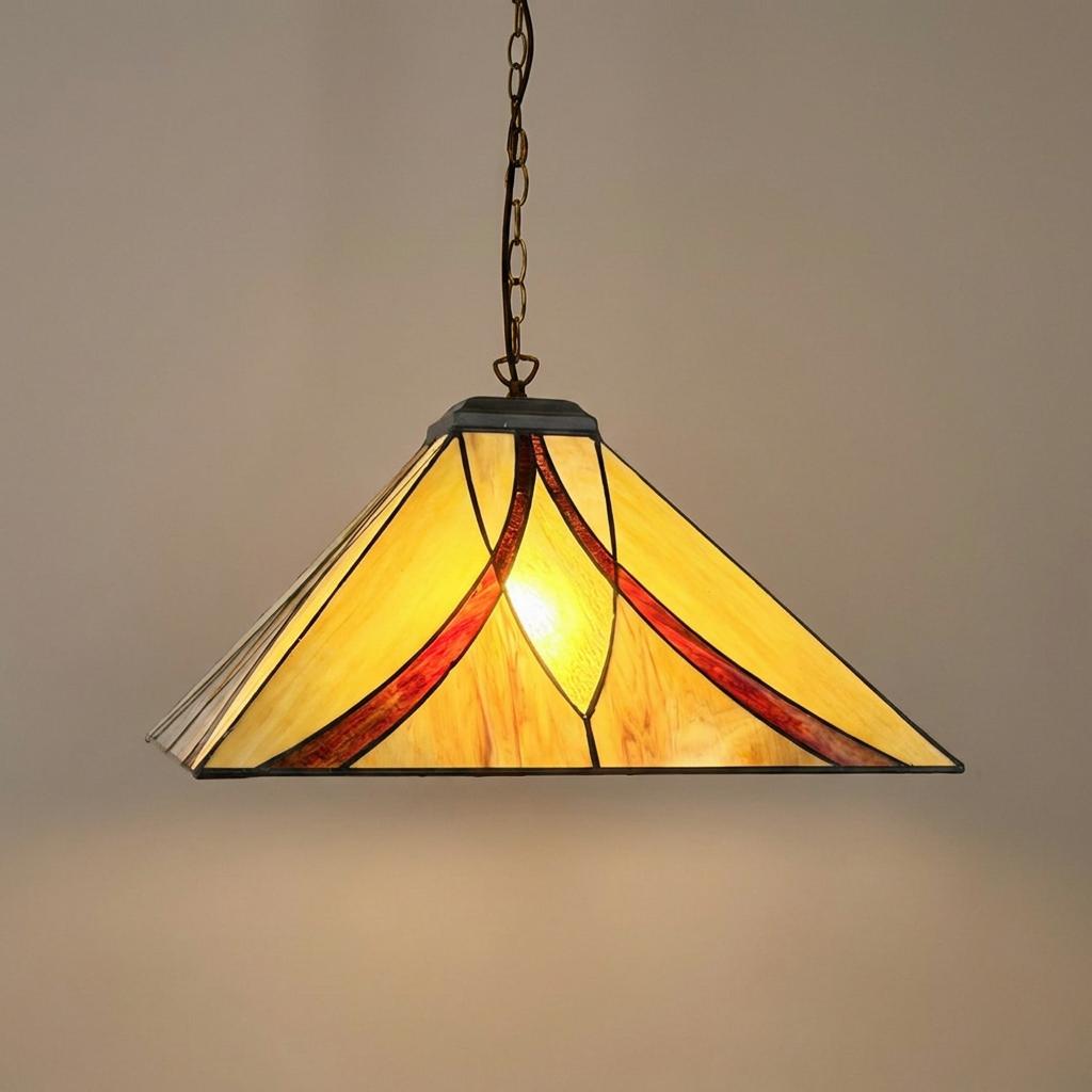 Illuminated Tiffany pendant light with a pyramid-shaped amber glass shade and red accents hanging from a chain.
