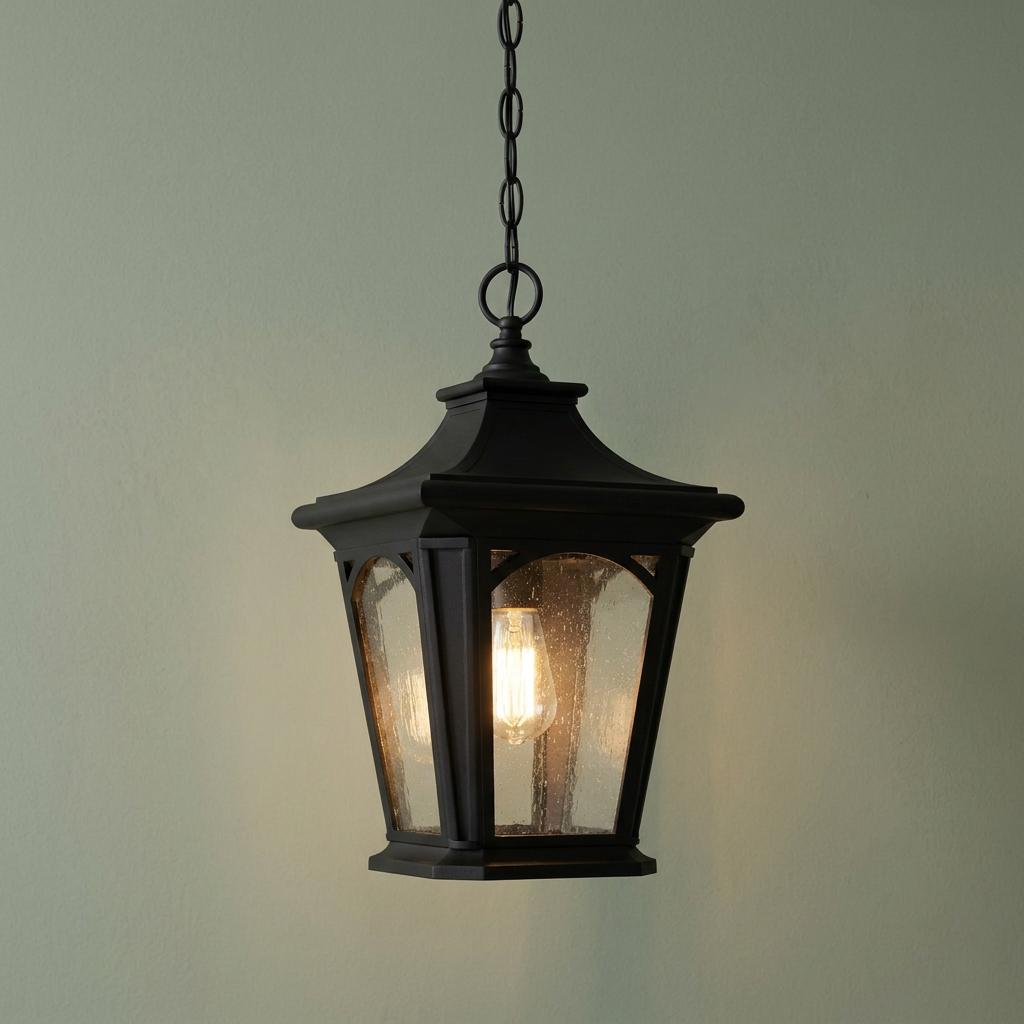 Traditional black outdoor pendant lantern with seeded glass panels and an illuminated Edison bulb.