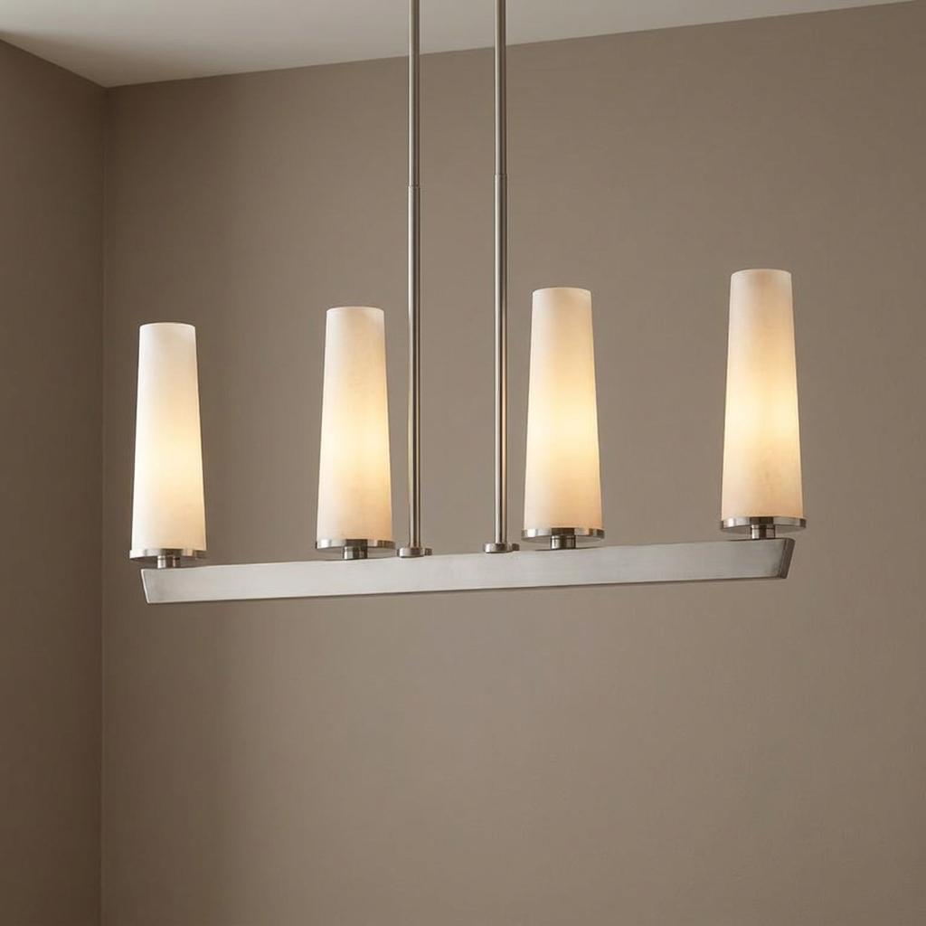 Four-light linear pendant with brushed nickel hardware and tapered white glass shades against a neutral wall.