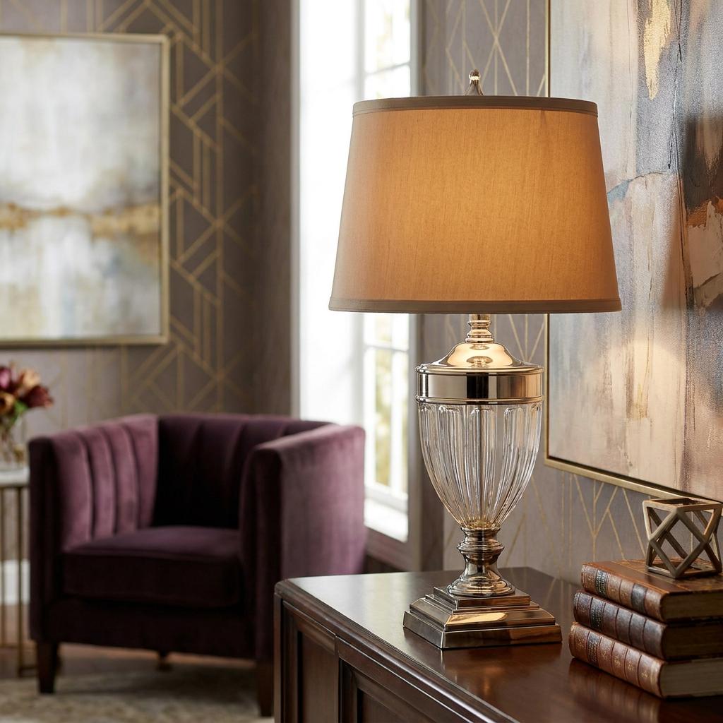 Lit Quoizel Dennison table lamp with a fluted glass base and fabric shade on a wooden sideboard in an elegant room.