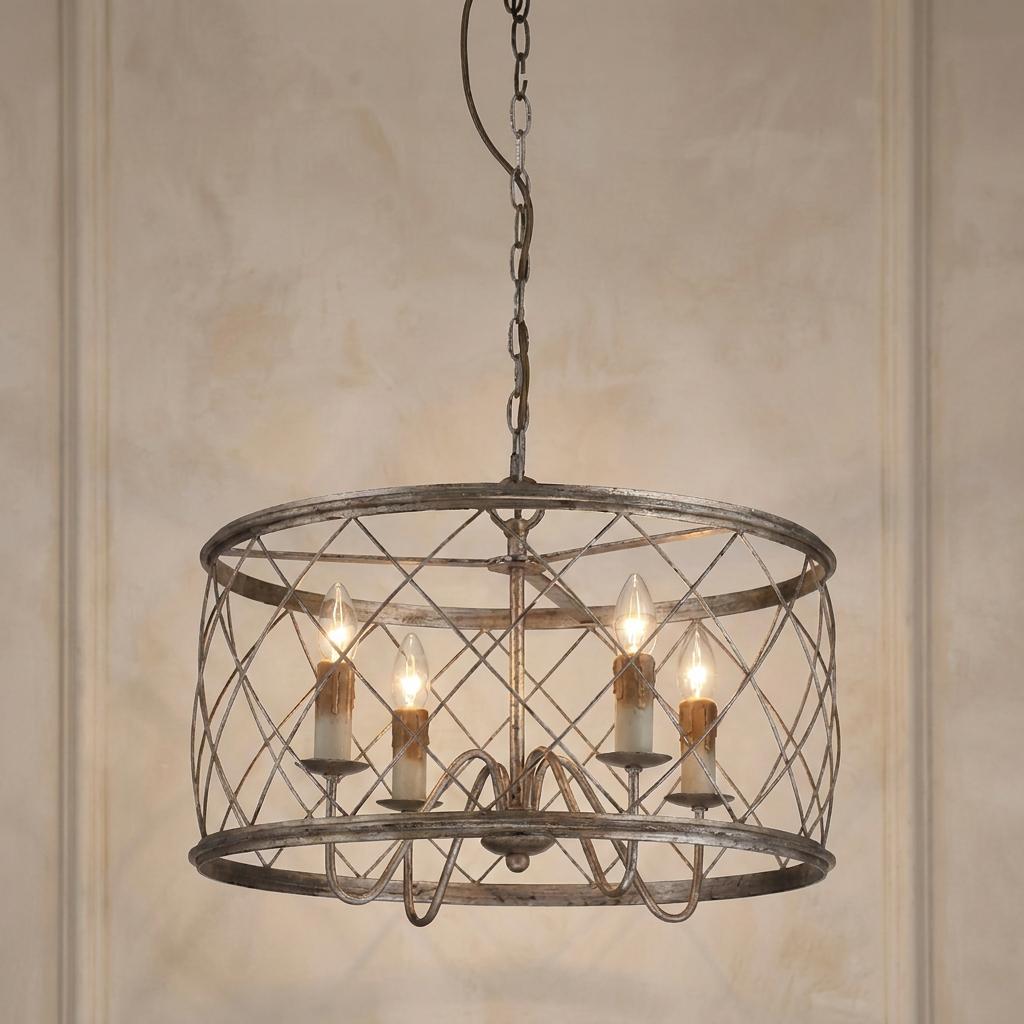Silver 4-light pendant with a criss-cross cage shade and candle bulbs hanging against a textured neutral wall.