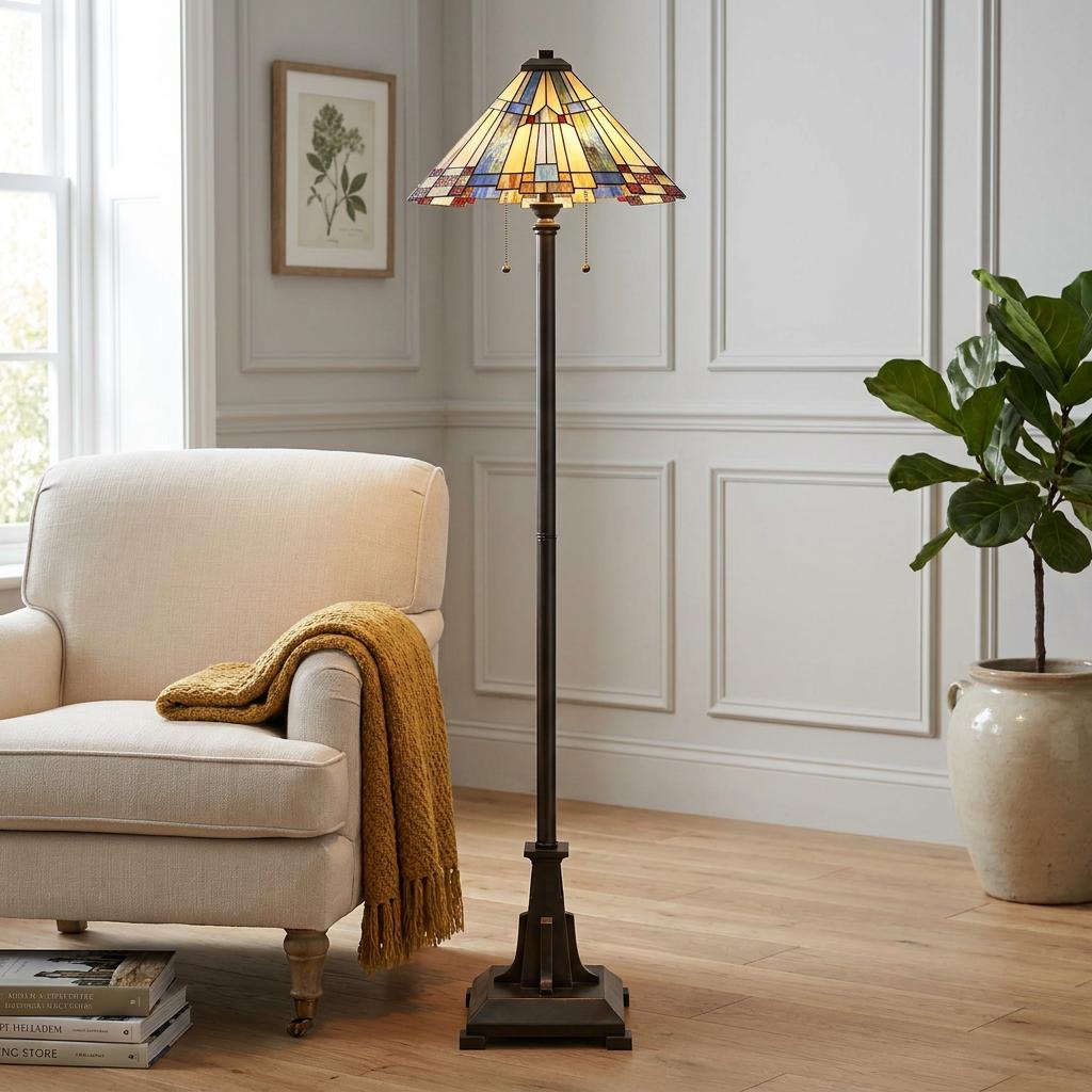 Quoizel Inglenook Tiffany floor lamp with a colorful geometric glass shade next to a cream armchair.