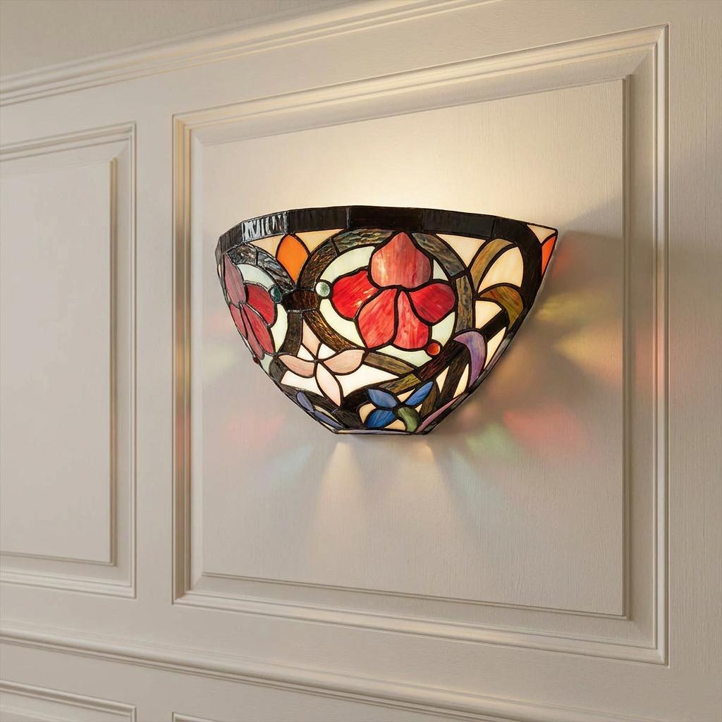 Tiffany-style floral stained glass wall sconce glowing on a white paneled wall.
