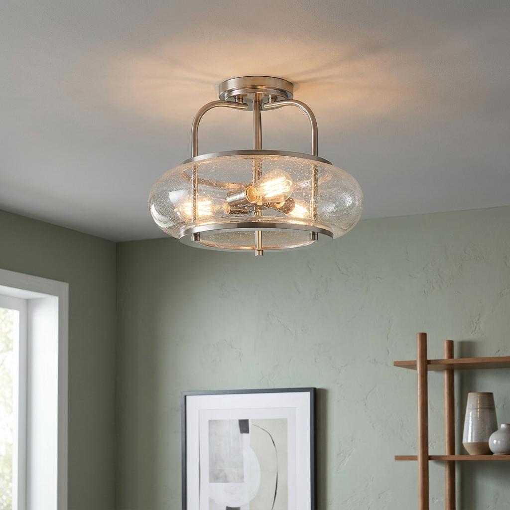 Brushed nickel semi-flush ceiling light with seeded glass shade and three glowing bulbs in a green-walled room.