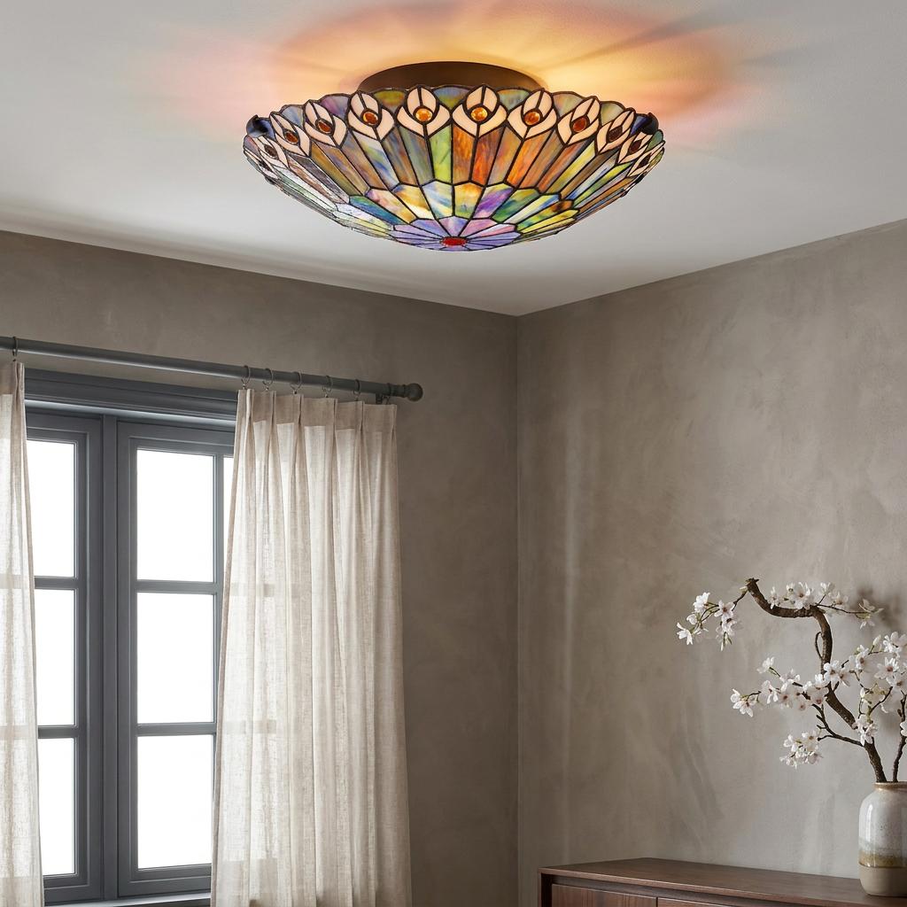 Colorful Tiffany flush ceiling light with a peacock feather design illuminating a grey-walled room.