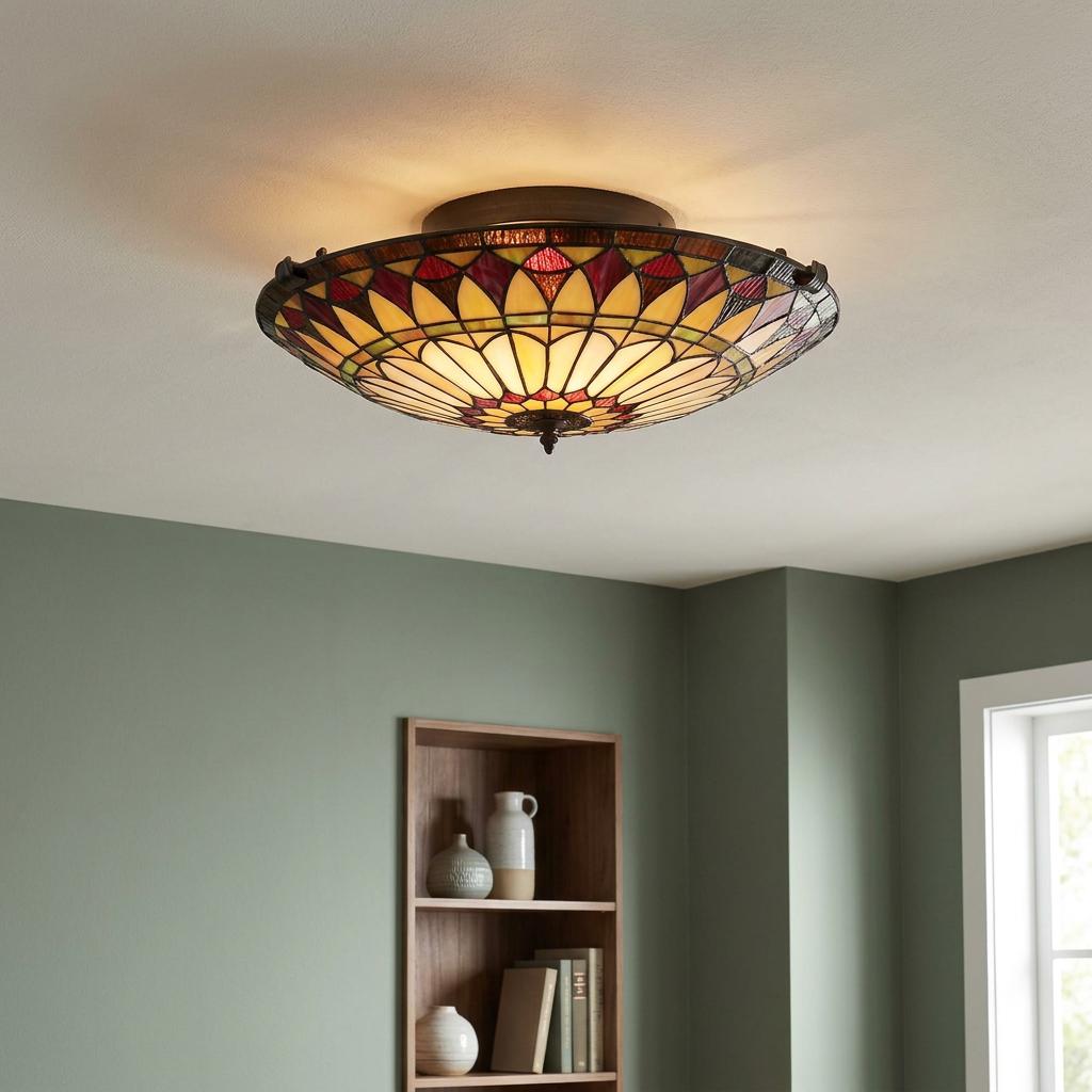 Illuminated Tiffany-style stained glass flush mount ceiling light with a yellow and red sunburst pattern.