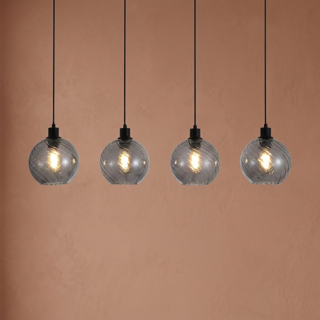 Four linear smoked glass pendant lights with spiral patterns and black fittings against a terracotta wall.